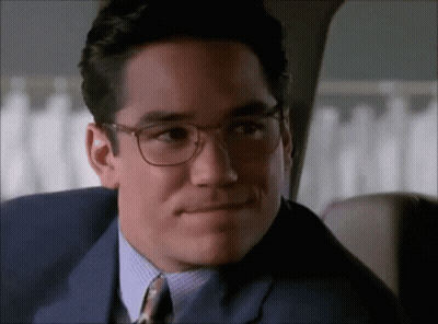 A Man Wearing Glasses And A Suit Looks At The Camera GIF