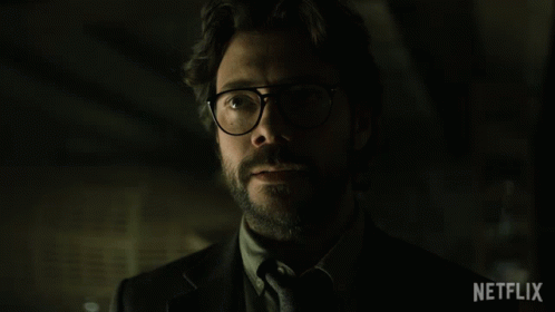 A Man Wearing Glasses And A Suit Says Gracias In Spanish GIF