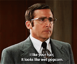 A Man Wearing Glasses And A Suit Says I Like Your Hair It Looks Like Wet Popcorn GIF