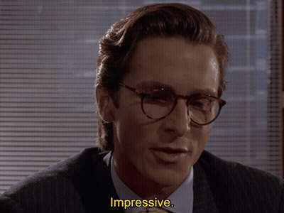 A Man Wearing Glasses And A Suit Says Impressive In Yellow Letters GIF