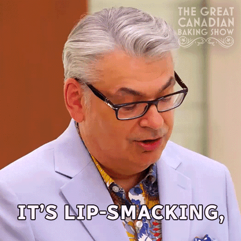 Man In Glasses And Suit Says Lip-Smacking GIF