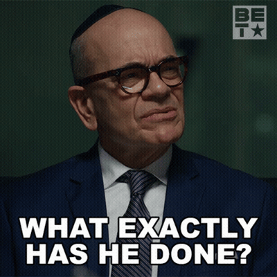 A Man Wearing Glasses And A Suit Says What Exactly Has He Done GIF