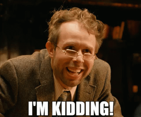 A Man Wearing Glasses And A Suit Smiles And Says " I 'M Kidding " GIF