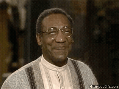 A Man Wearing Glasses And A Sweater Is Smiling And Looking Up . GIF