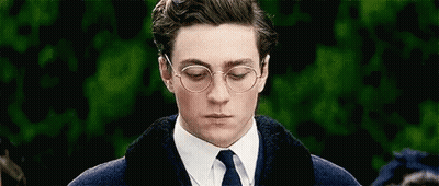 A Man Wearing Glasses And A Tie Is Looking Down . GIF