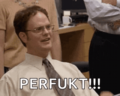 A Man Wearing Glasses And A Tie Is Sitting In A Chair With The Words Perfukt Written On His Face . GIF