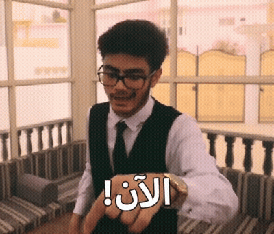 A Man Wearing Glasses And A Vest Has A Watch On His Wrist That Says ' I 'M Late ' GIF