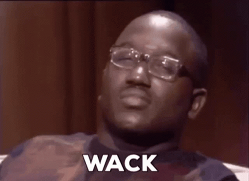 A Man Wearing Glasses And A Vest Is Sitting On A Couch And Says Wack . GIF
