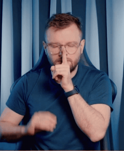 A Man Wearing Glasses And A Watch Is Making A Shhh Gesture GIF