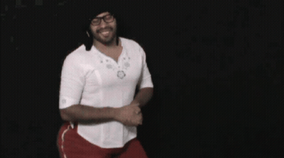 A Man Wearing Glasses And A White Shirt Is Dancing In Front Of A Black Background GIF
