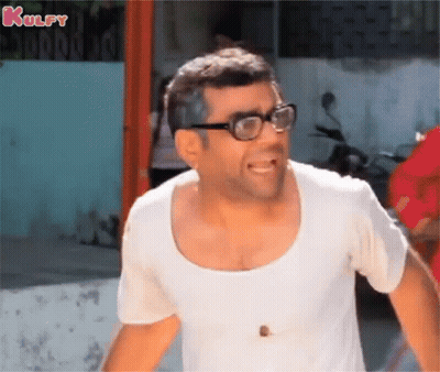 A Man Wearing Glasses And A White Shirt Is Laughing . GIF