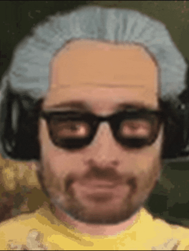 A Man Wearing Glasses And A Wig Is Smiling GIF