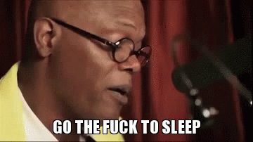 A Man Wearing Glasses And A Yellow Jacket Is Speaking Into A Microphone And Says `` Go The Fuck To Sleep '' . GIF