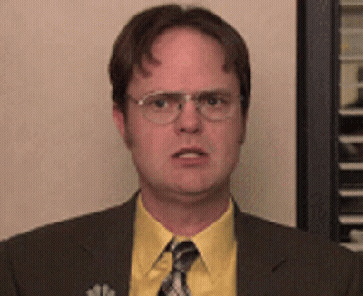 A Man Wearing Glasses And A Yellow Shirt Is Making A Funny Face GIF