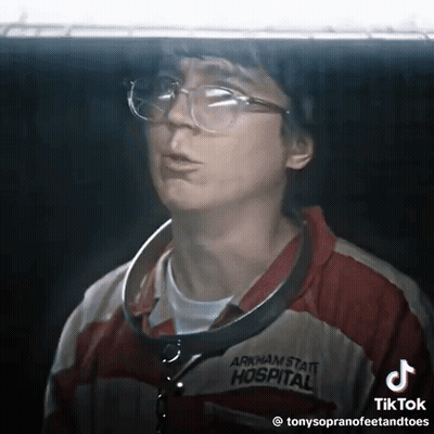 A Man Wearing Glasses And An Arkham State Hospital Jacket GIF