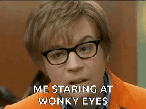 A Man Wearing Glasses And An Orange Jacket Is Making A Funny Face And Saying `` Me Staring At Wonky Eyes '' . GIF