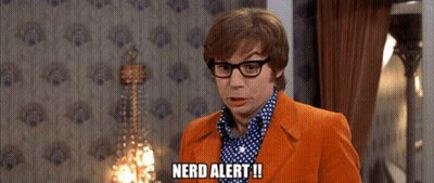 A Man Wearing Glasses And An Orange Suit Says Nerd Alert GIF
