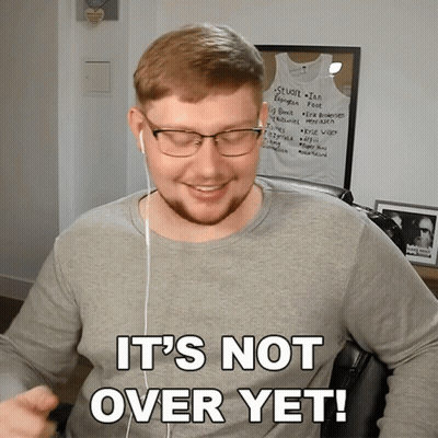 A Man Wearing Glasses And Ear Buds Says " It 'S Not Over Yet " GIF