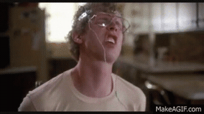 A Man Wearing Glasses And Headphones Is Making A Funny Face In A Kitchen . GIF