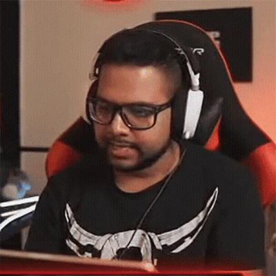 A Man Wearing Glasses And Headphones Is Sitting In A Chair . GIF