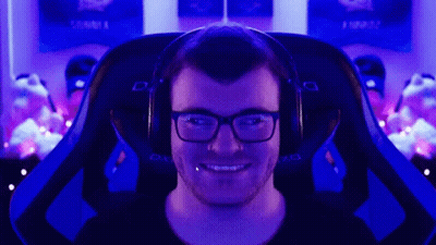 A Man Wearing Glasses And Headphones Is Sitting In A Dxracer Gaming Chair GIF