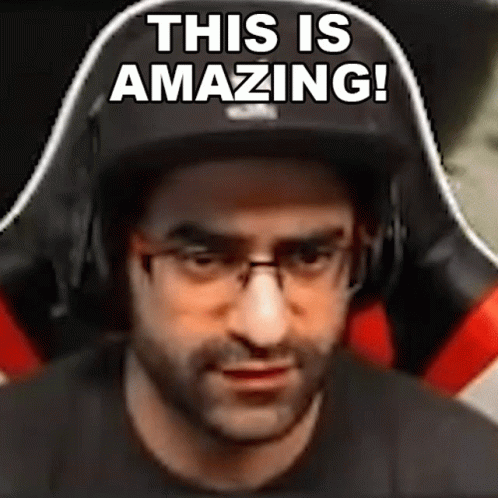 A Man Wearing Glasses And Headphones Is Sitting In A Gaming Chair And Says `` This Is Amazing ! '' GIF