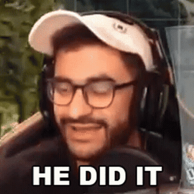 A Man Wearing Glasses And Headphones Is Sitting In Front Of A Microphone And Smiling . GIF