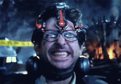 A Man Wearing Glasses And Headphones Is Smiling While Wearing A Helmet On His Head . GIF