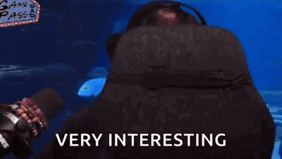 A Man Wearing Glasses And Headphones Says Very Interesting In Front Of An Aquarium GIF