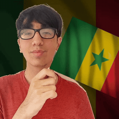 A Man Wearing Glasses Holds A Flag In Front Of A Green Yellow And Red Flag GIF