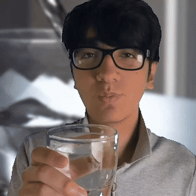 A Man Wearing Glasses Holds A Glass Of Water GIF