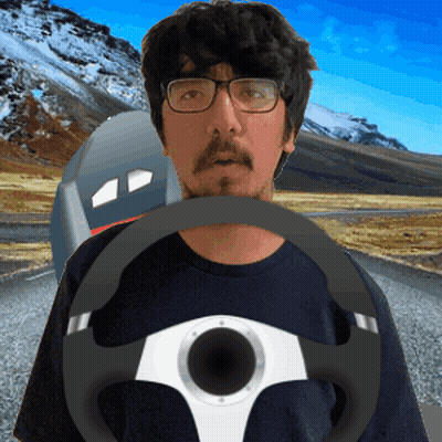 A Man Wearing Glasses Holds A Steering Wheel In His Hand GIF