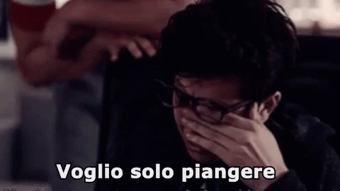 A Man Wearing Glasses Is Crying While Talking On A Phone . GIF