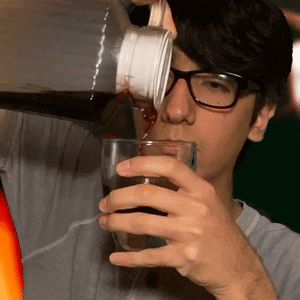 A Man Wearing Glasses Is Drinking From A Bottle GIF