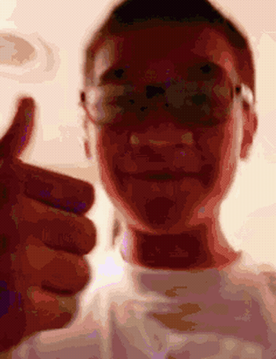A Man Wearing Glasses Is Giving A Thumbs Up GIF