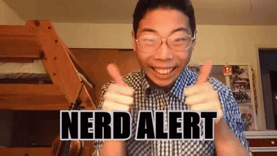 A Man Wearing Glasses Is Giving A Thumbs Up With The Words Nerd Alert Written On His Chest GIF
