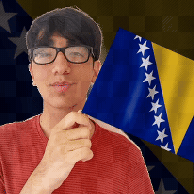 A Man Wearing Glasses Is Holding A Flag In Front Of A Flag With Stars On It GIF