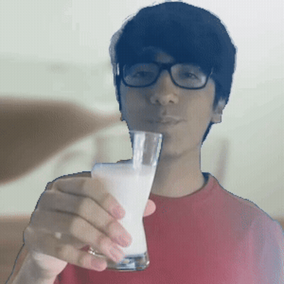 A Man Wearing Glasses Is Holding A Glass Of Milk In Front Of His Face GIF
