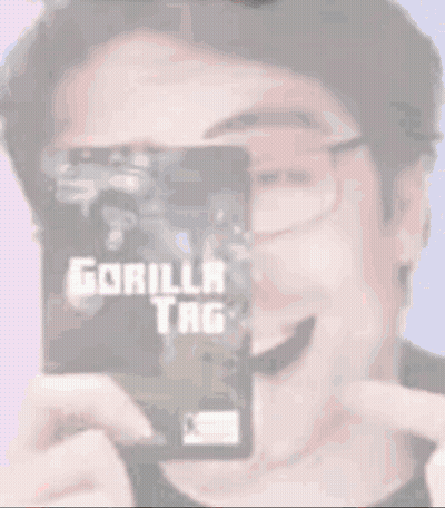 A Man Wearing Glasses Is Holding A Gorilla Tag Card GIF