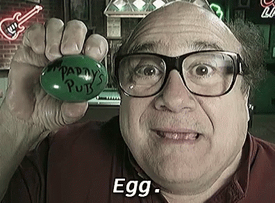 A Man Wearing Glasses Is Holding A Green Egg With The Words `` Paddy 'S Pub '' Written On It . GIF