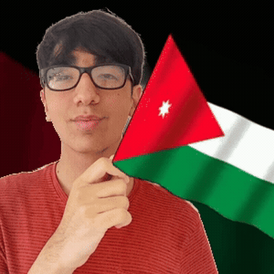 A Man Wearing Glasses Is Holding A Small Flag In Front Of His Face GIF