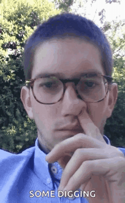 A Man Wearing Glasses Is Holding His Nose With His Finger . GIF