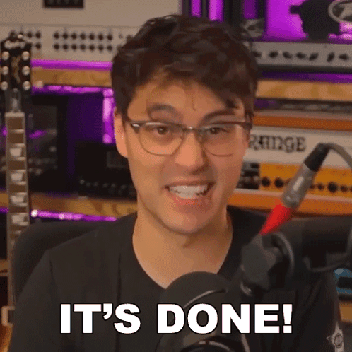 A Man Wearing Glasses Is In Front Of A Microphone And Says It 'S Done . GIF