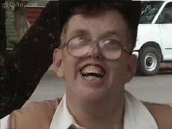 A Man Wearing Glasses Is Making A Funny Face In Front Of A White Van . GIF