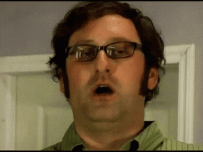 A Man Wearing Glasses Is Making A Funny Face . GIF
