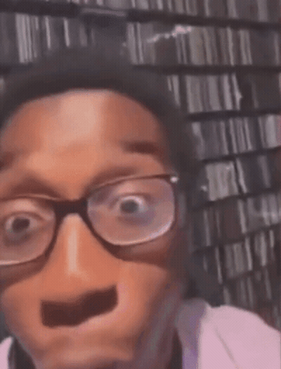 A Man Wearing Glasses Is Making A Funny Face . GIF