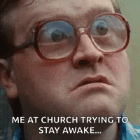 A Man Wearing Glasses Is Making A Funny Face While Trying To Stay Awake . GIF