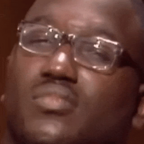 A Man Wearing Glasses Is Making A Funny Face With His Mouth Open . GIF