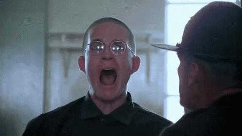 A Man Wearing Glasses Is Screaming At Another Man In A Black Shirt . GIF