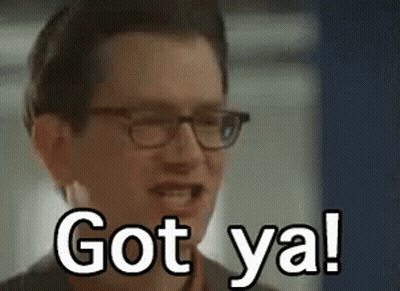 A Man Wearing Glasses Is Smiling And Saying `` Got Ya ! '' GIF